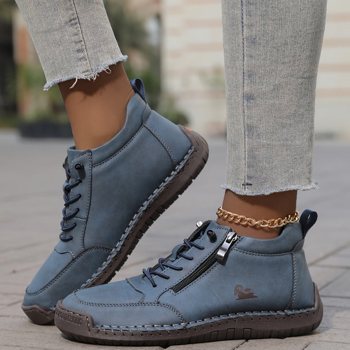 Blue lace-up comfort shoes with side zipper, contrast stitching, and gold ankle chain