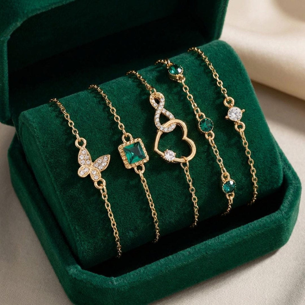 Gold-tone charm bracelet set with green crystal stones and mixed charms: butterfly, square, heart