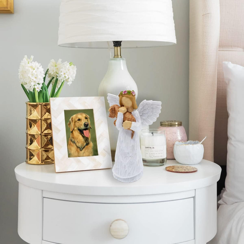 Dog memorial angel figurine on table with bracelet and framed photo