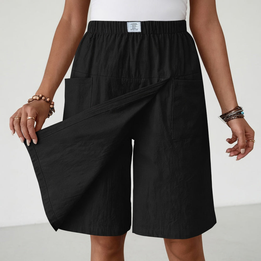 Black elastic waist skort with deep pockets and a front crossover panel