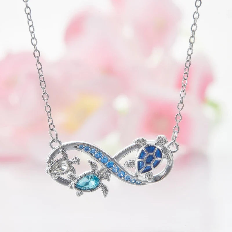 Silver infinity turtle pendant necklace with blue crystal trim and turtle shell accents