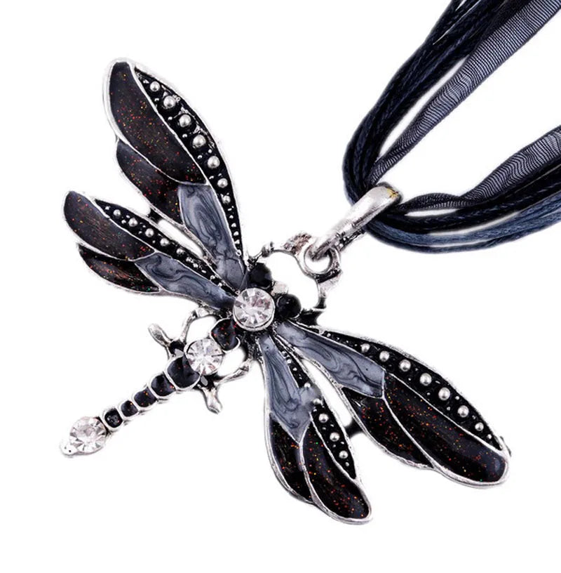 Dark dragonfly pendant necklace with clear stones and dark ribbon cord.