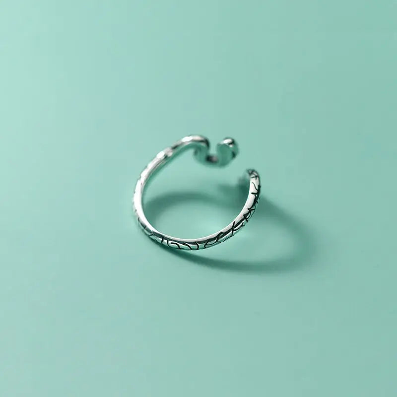 Sterling silver snake ring with engraved snake pattern on a curved band