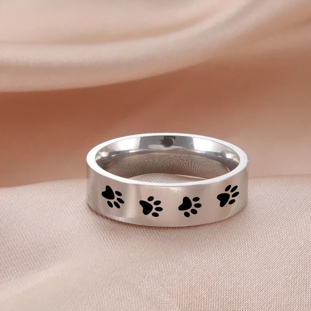 Silver paw print ring with black paw designs along the band