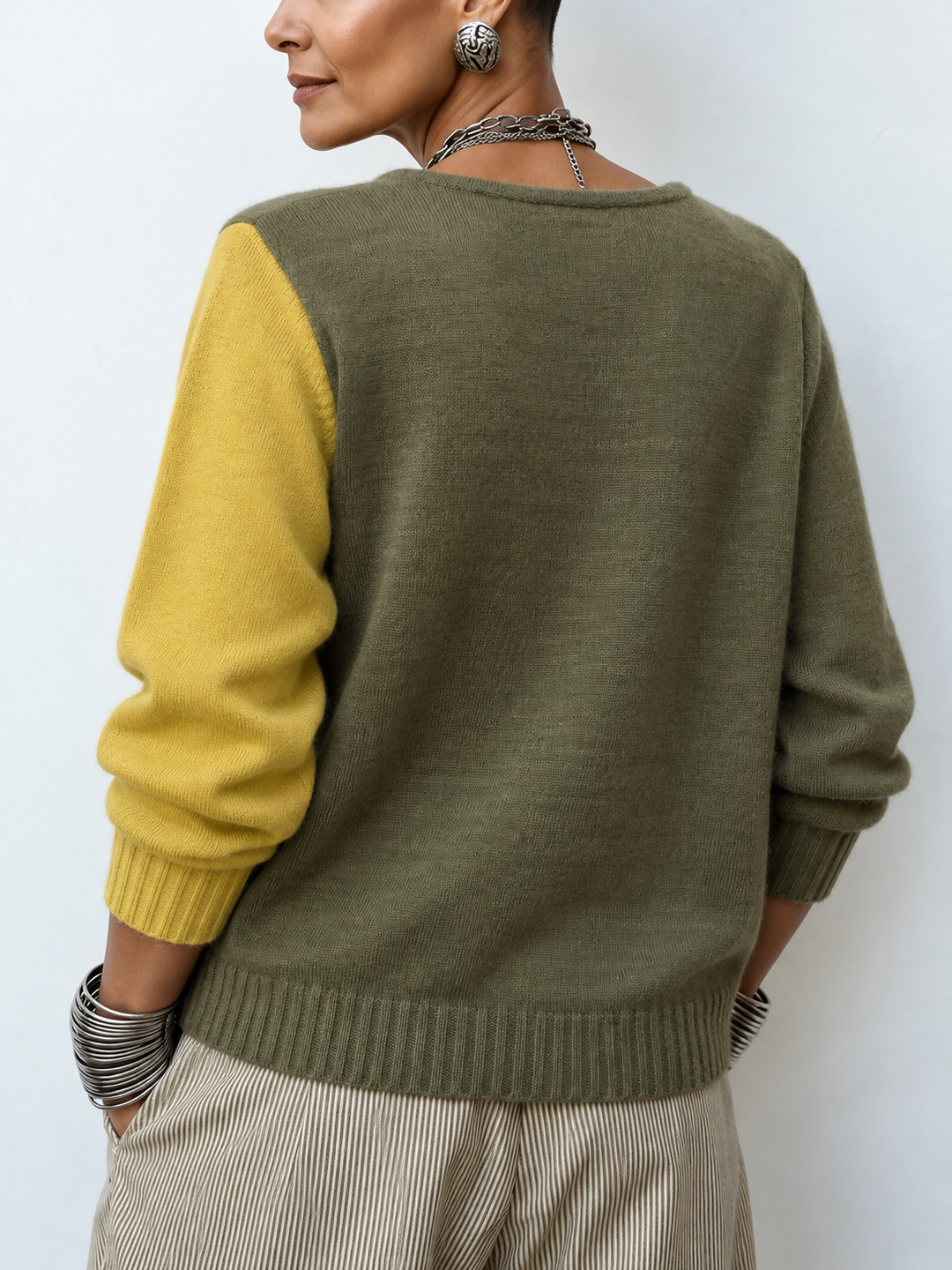 Asymmetric colourblock sweater back view with olive upper and mustard sleeve