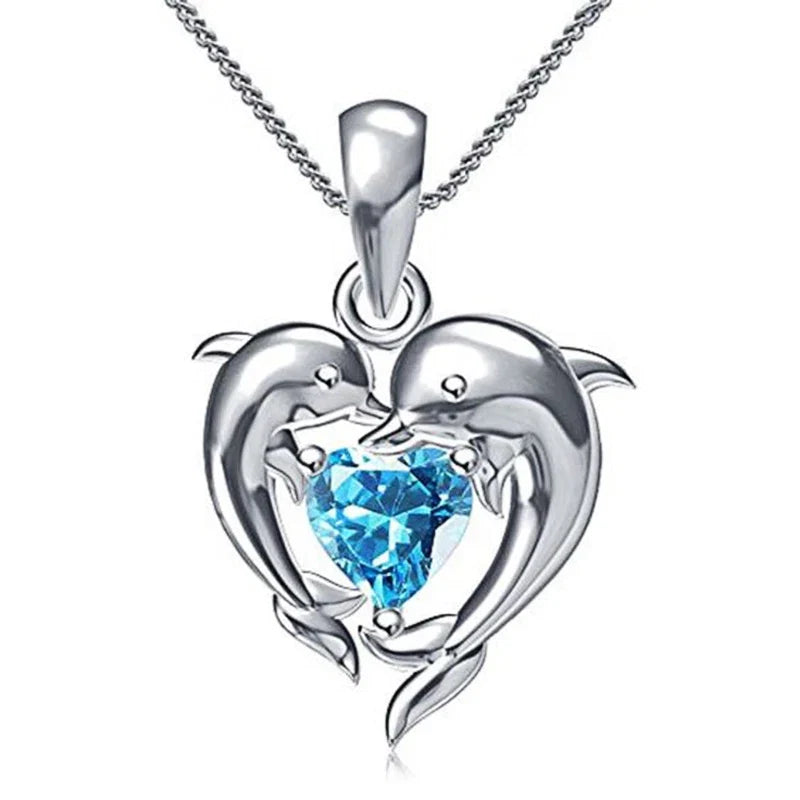 Silver dolphin heart pendant necklace with a blue faceted heart crystal centerpiece