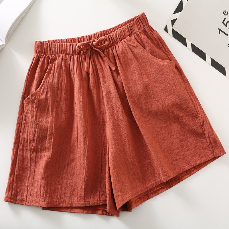 Minimalist relaxed-fit shorts in rust red, elastic waistband and drawstring tie.