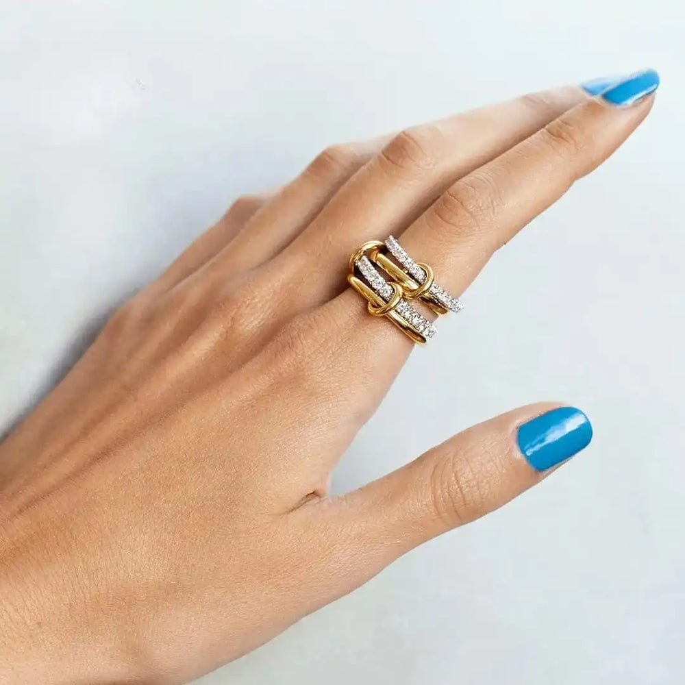 Intertwined zirconia ring set in gold and silver on a hand