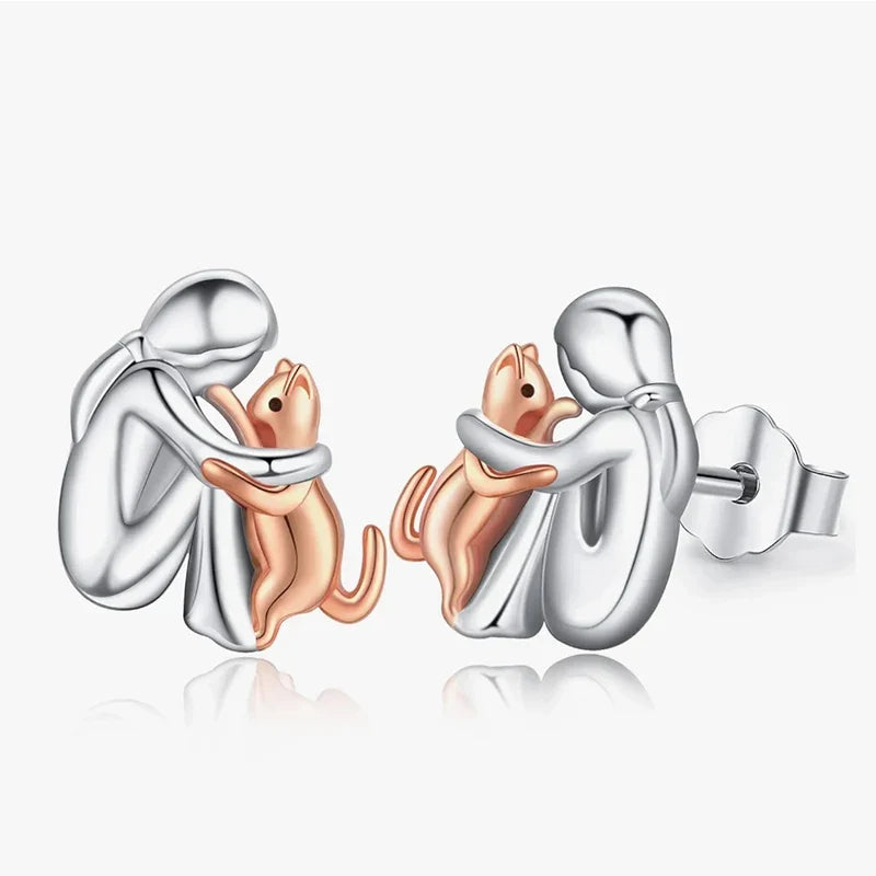 Two-tone cat hug stud earrings with silver cats and orange-toned hugging cat design