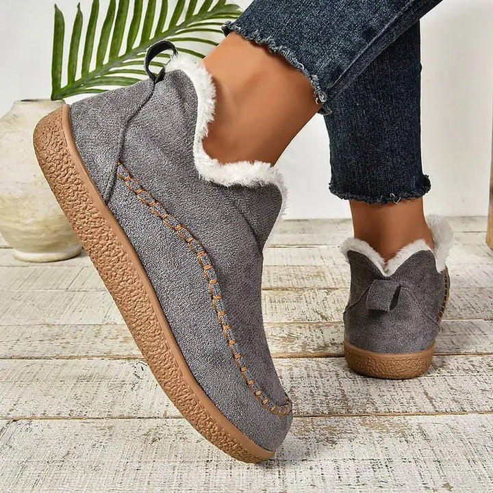 Grey ankle boots with sherpa-style lining and orange-stitched moccasin detailing