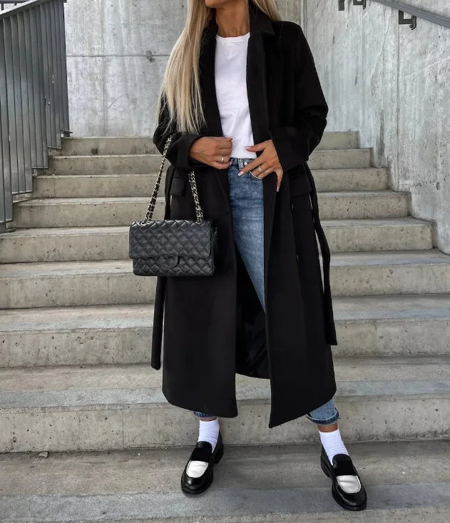 Black long sleeve trench coat with belt, notched lapels, and double-breasted button front