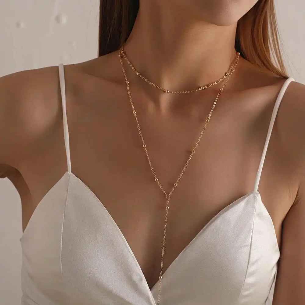 Gold long double-layer bead necklace with thin chains and dangling tassel