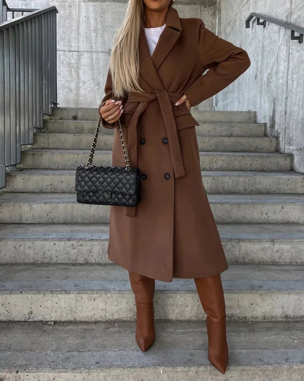 Brown long sleeve trench coat with tie belt, notched lapels, and double-breasted buttons