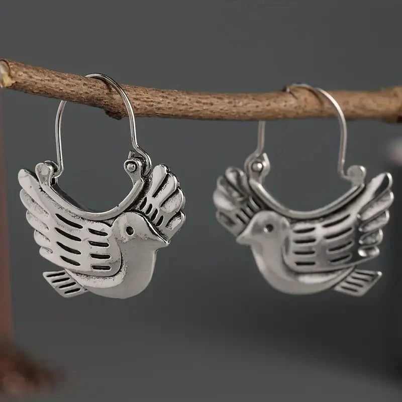 Silver-tone bird dangle earrings on a branch, winged bird charms on round hoops