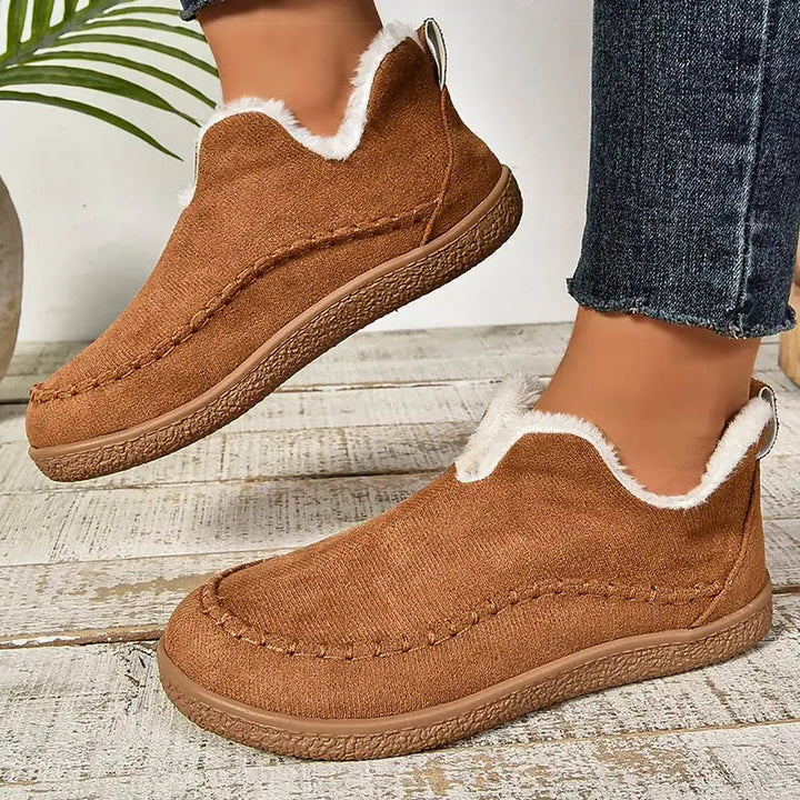 Brown ankle boots with faux-fur collar lining, moccasin stitch seams, and grippy sole