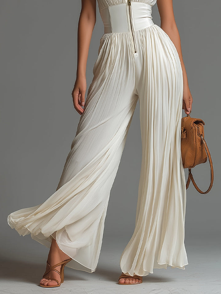 White chiffon sleeveless jumpsuit with V-neck and zip, pleated and wide leg