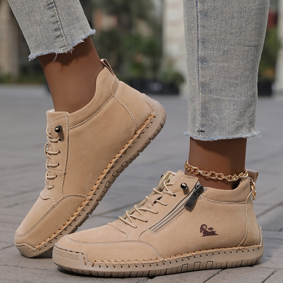 Beige lace-up comfort shoes with side zipper, tan sole, and gold chain strap