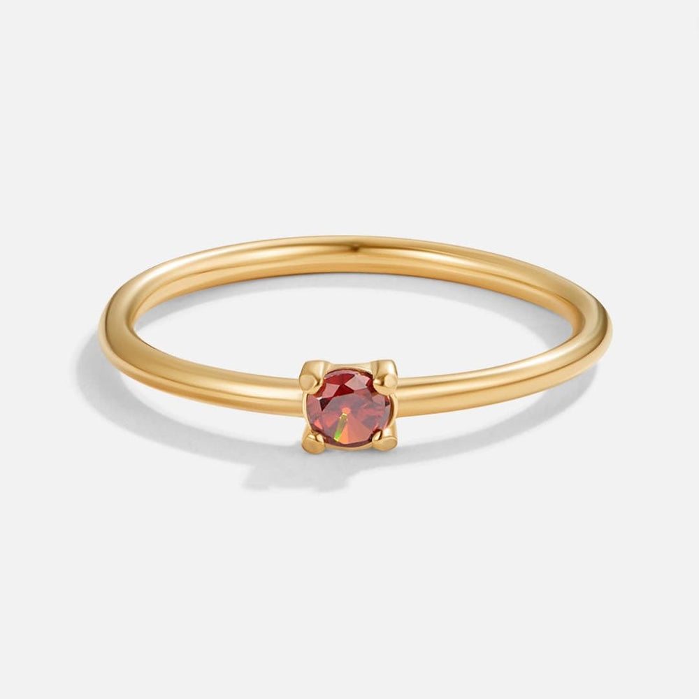Gold birthstone ring with oval red gemstone in a four-prong setting