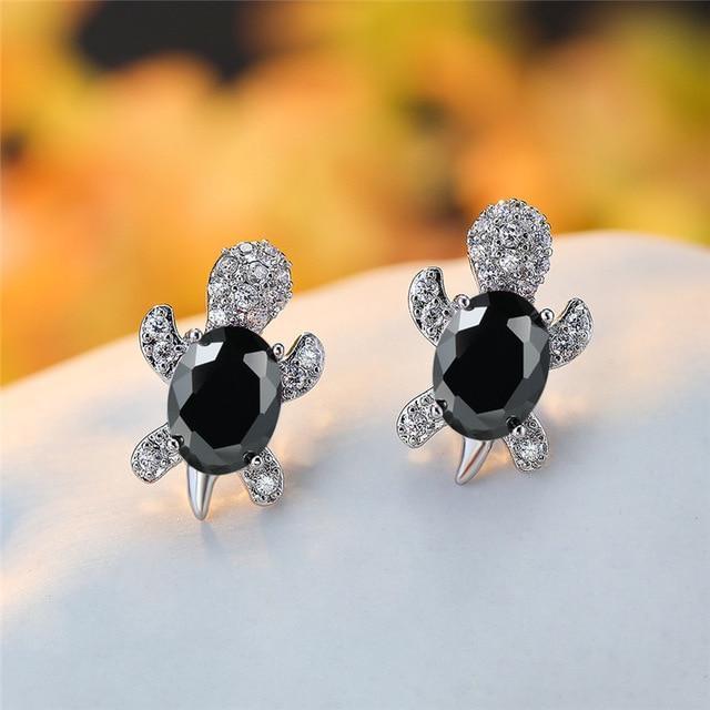 Sea turtle stud earrings with dark black zirconium center and silver-toned shell accents.