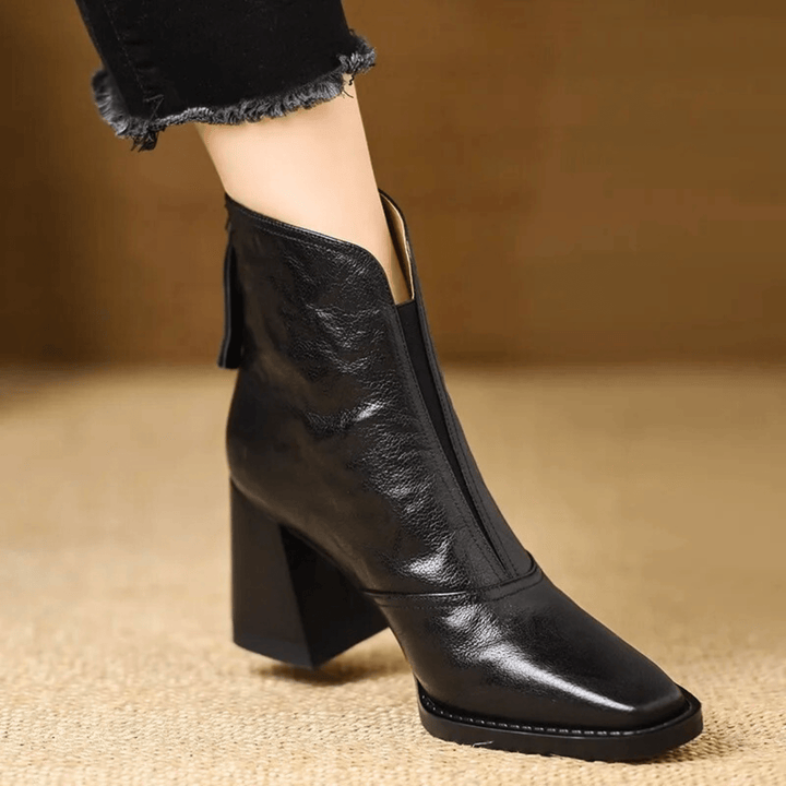 Black faux leather ankle boots with mid block heel, pointed-toe pull-on design